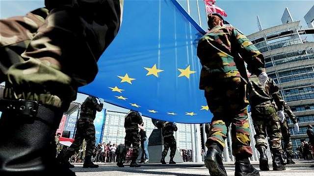 Troops carrying EU flag in front of the EU Parliament in Brussels. 